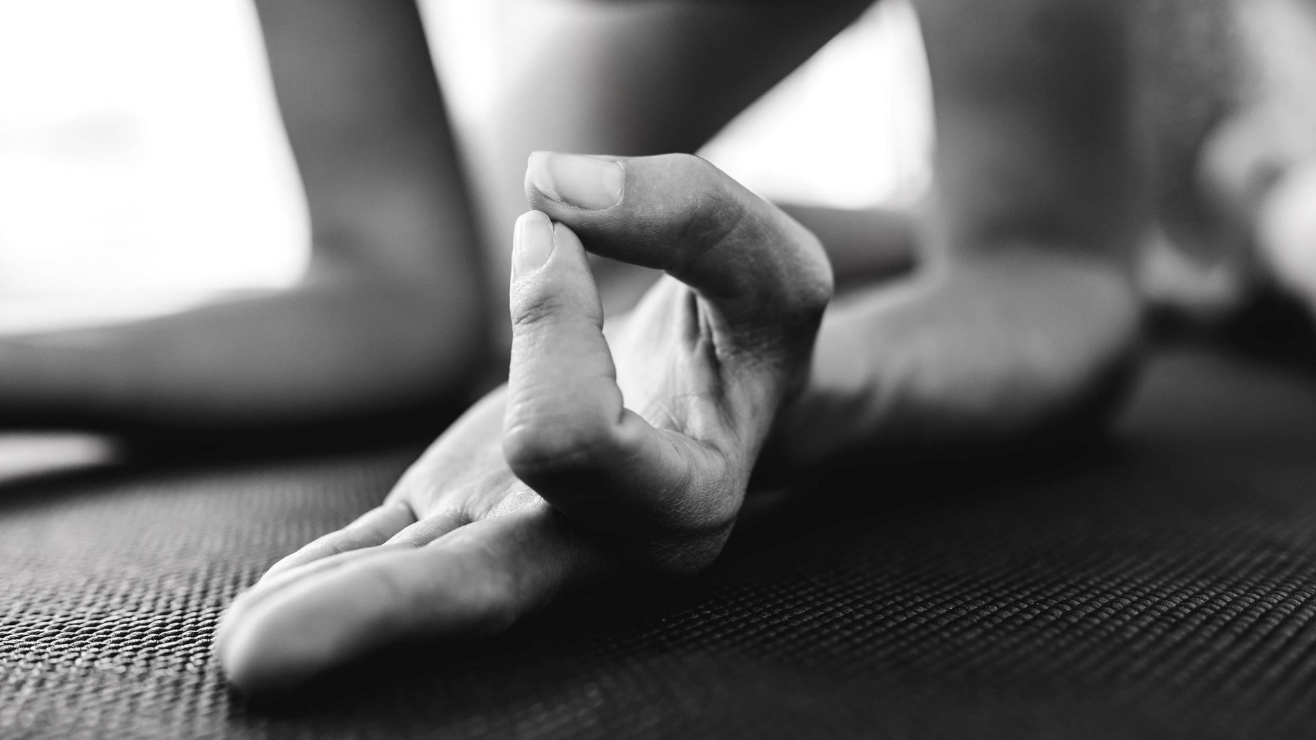 A hotel with spa for families with fitness area Hand in mudra position during meditation on yoga mat