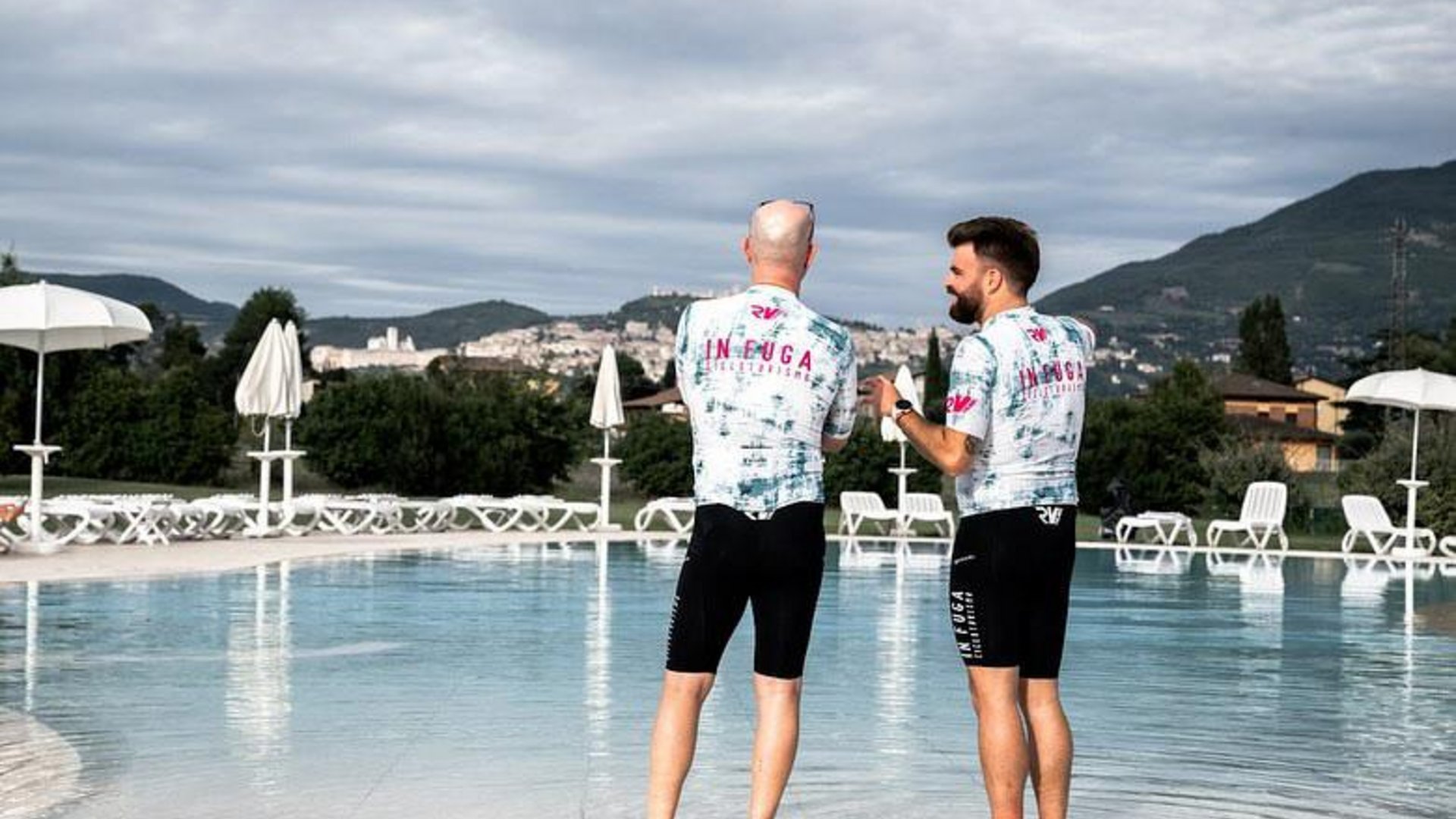 A holiday near Assisi: activities galore Two men in sportswear standing with feet in water at an outdoor pool
