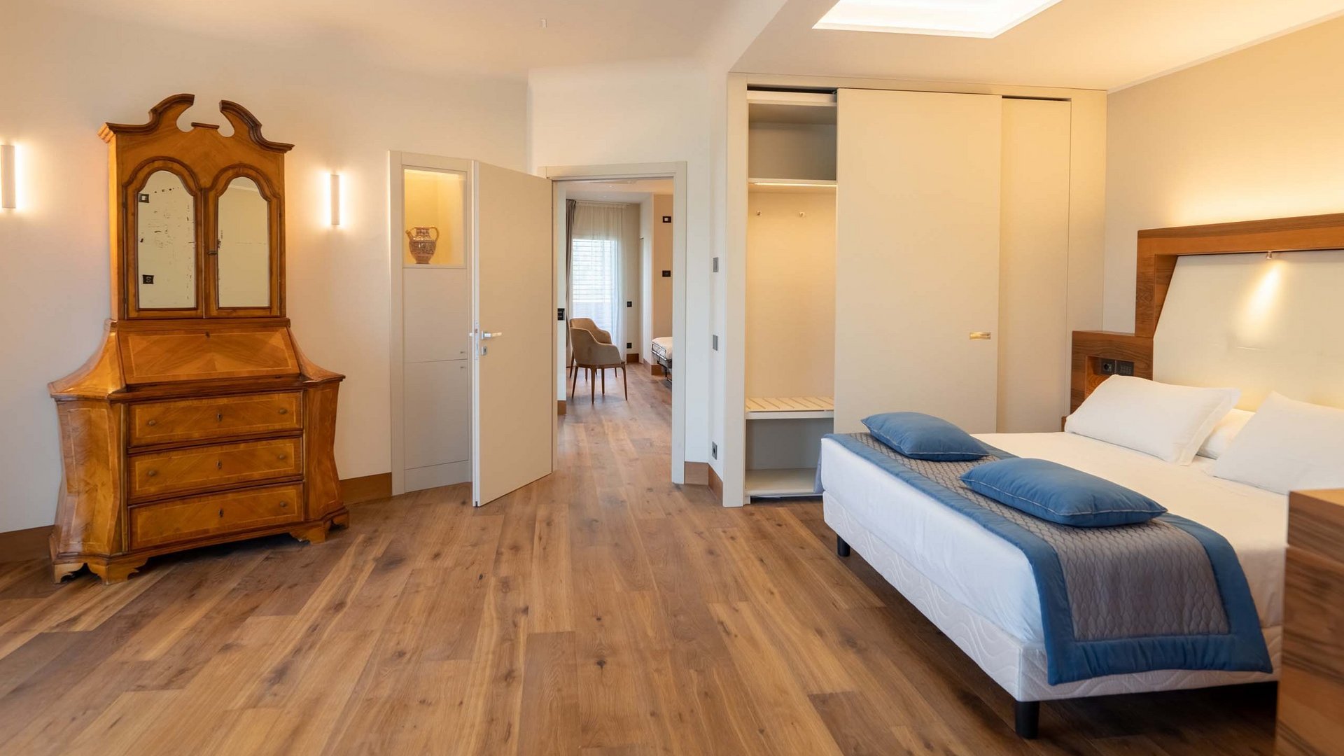 Urlaub in Umbrien? Und noch viel mehr! Modernes Schlafzimmer mit Doppelbett, weißem Schrank und antiker Kommode