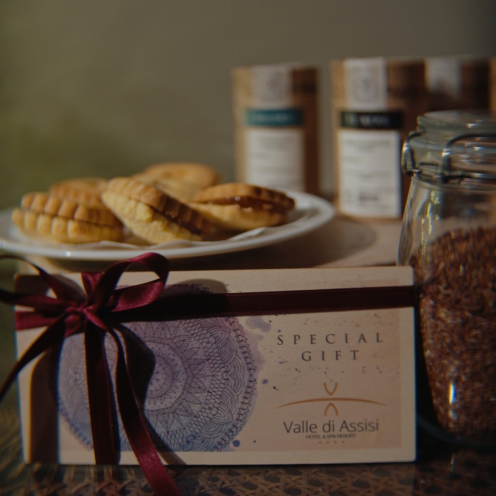 Natale e Inizio Anno a Valle di Assisi 2025 Confezione regalo speciale con biscotti su un piatto e barattolo di semi