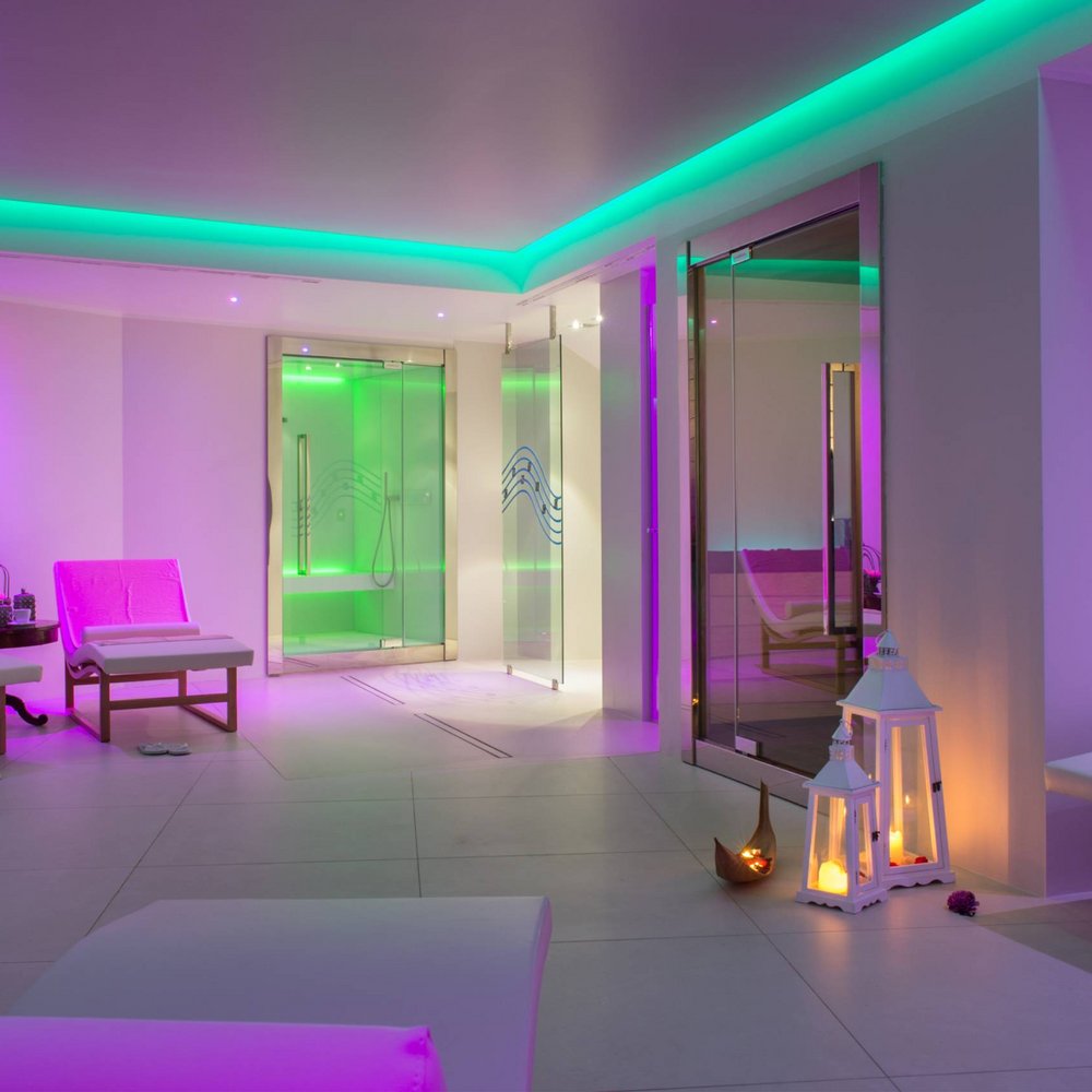 Unparalleled wellness in Umbria Spa interior with purple and green ambient lighting, loungers, and lit lanterns