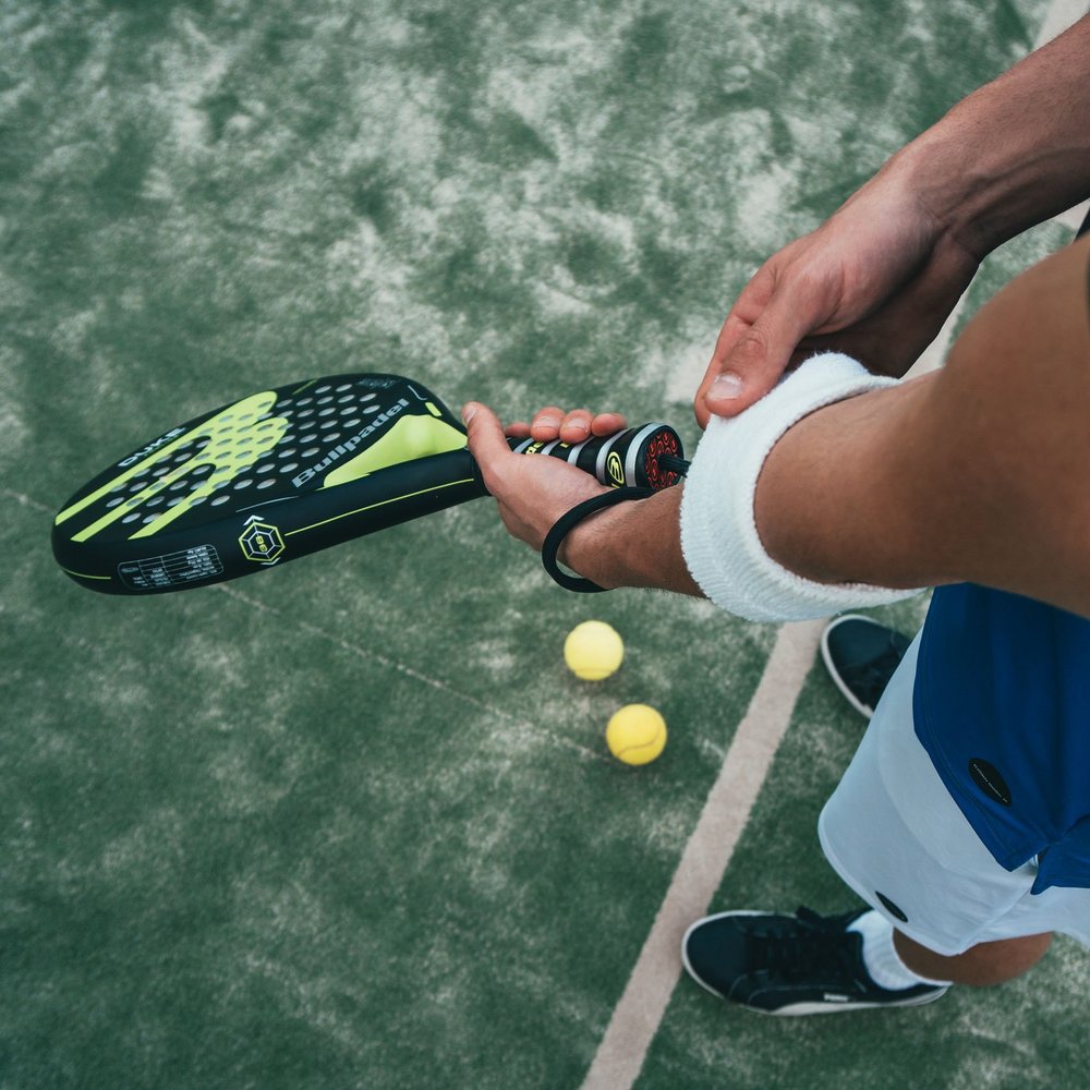 Vacanze in Umbria, vacanze di pienezza Giocatore di padel con racchetta e palline gialle sul campo verde