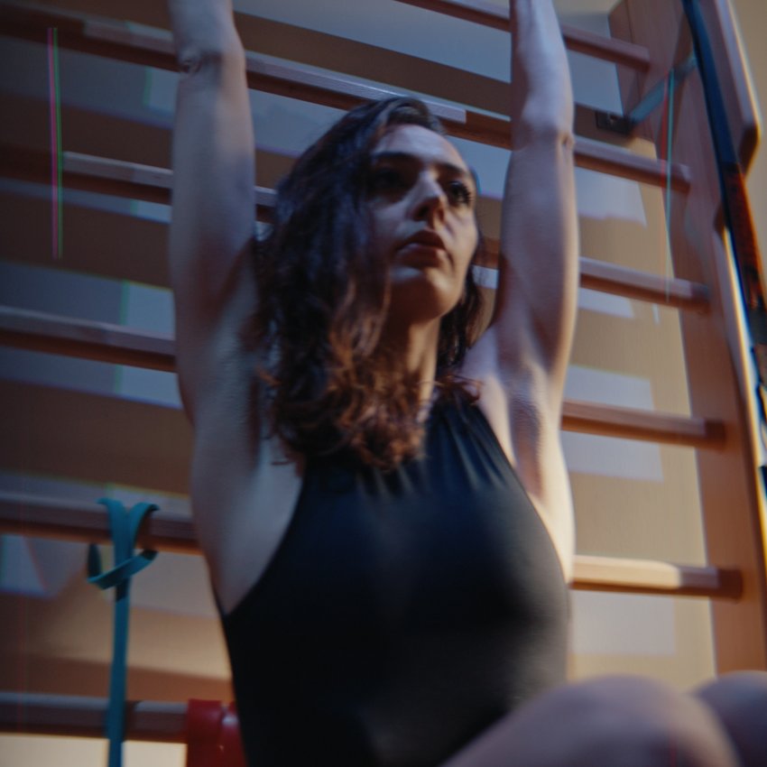 Un hotel con spa per famiglie e area fitness Donna che si allunga con le braccia sollevate in palestra