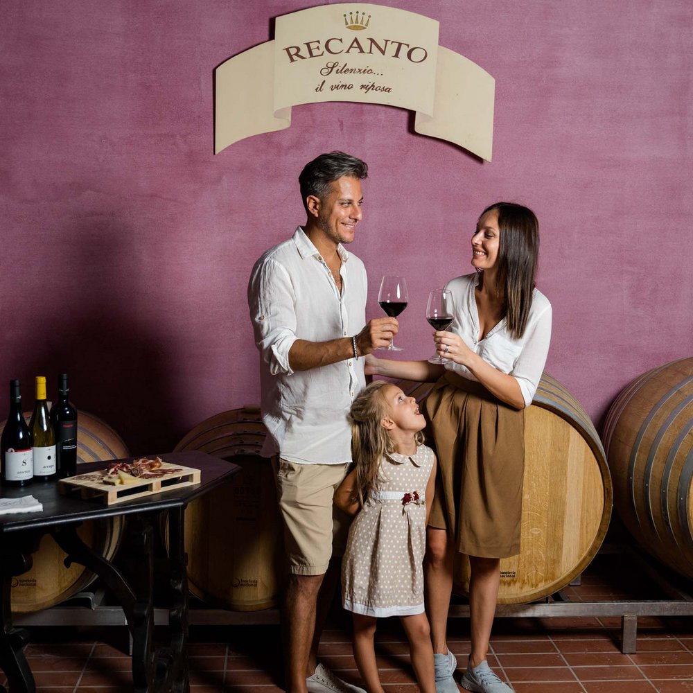 Vacanze in Umbria, vacanze di pienezza Famiglia in cantina con due adulti che brindano e bambina che li guarda
