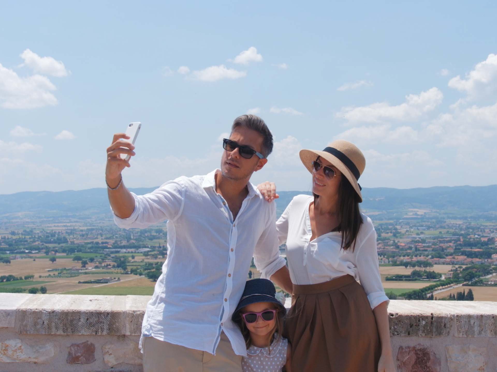 A Santa Maria degli Angeli - Assisi ( Perugia ) Centro Congressi e Meeting d'eccezione? I tuoi eventi vista Assisi Umbria Famiglia in vacanza che si fa un selfie con panorama rurale dietro
