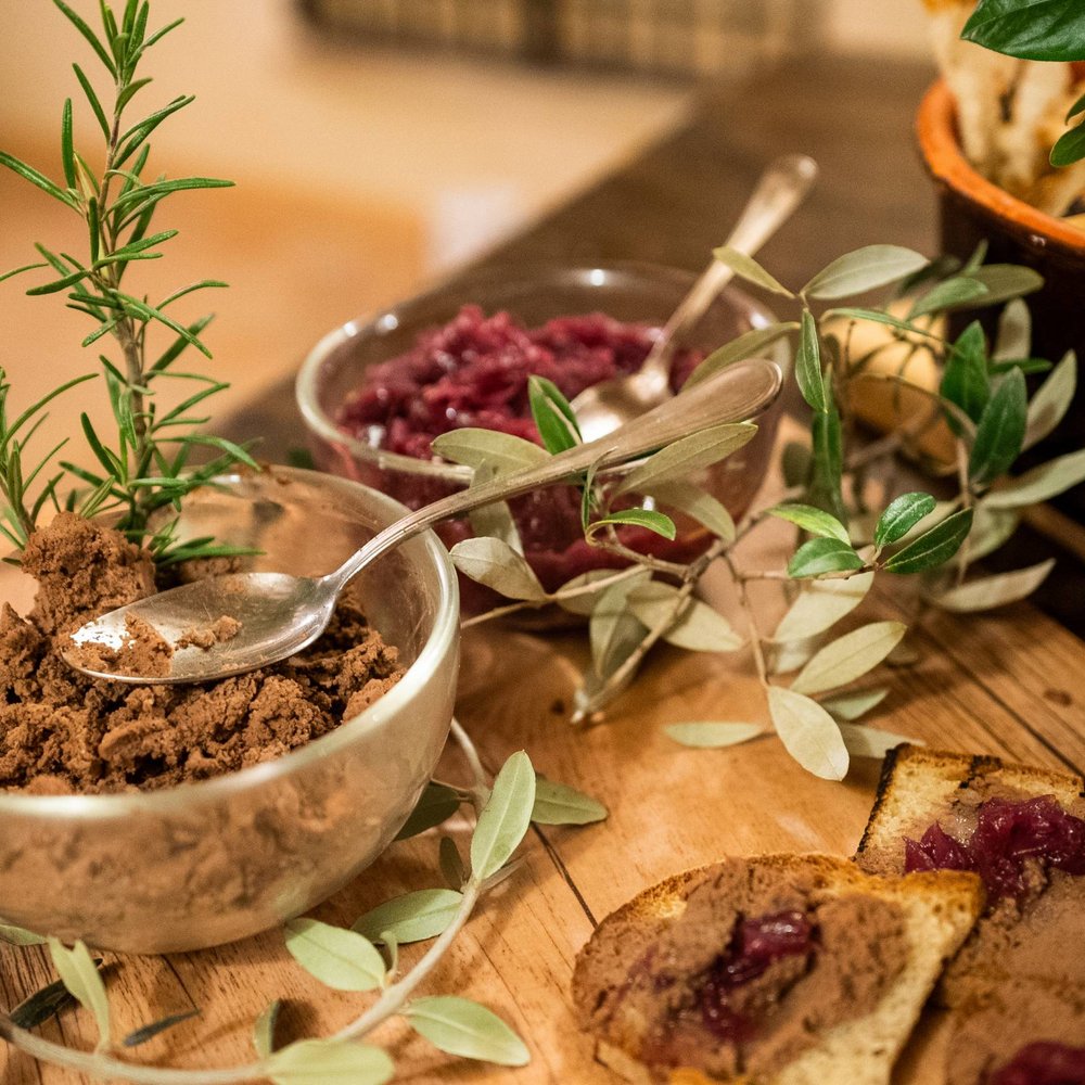 Family resort vicino ad Assisi con un ristorante da sogno Crostini con paté e marmellata su un tagliere in legno con ciotole di paté e marmellata