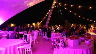 Perugia ha un Centro Meeting e Congressi d'eccezione: ai piedi di Assisi in Umbria Evento serale all'aperto con tavoli rotondi, decorazioni floreali e luci calde.