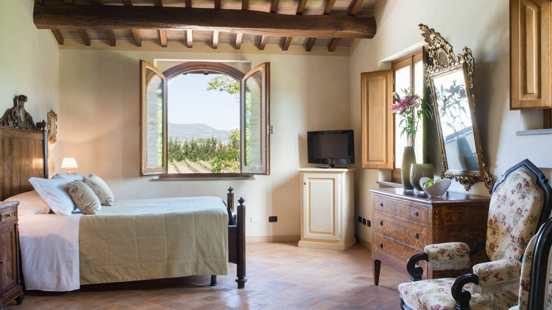 Ferienhaus in Umbrien mit Pool: in unserem Resort Rustikales Schlafzimmer mit Holzdeckenbalken und Blick auf die Landschaft