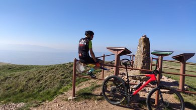 A holiday near Assisi: activities galore Cyclist sitting on fence with red bike on hilltop with panoramic view
