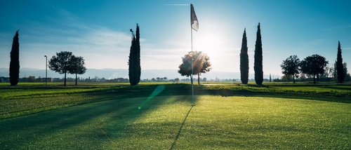 A Santa Maria degli Angeli - Assisi ( Perugia ) Centro Congressi e Meeting d'eccezione? I tuoi eventi vista Assisi Umbria Bandiera su campo da golf al tramonto con alberi e cielo limpido