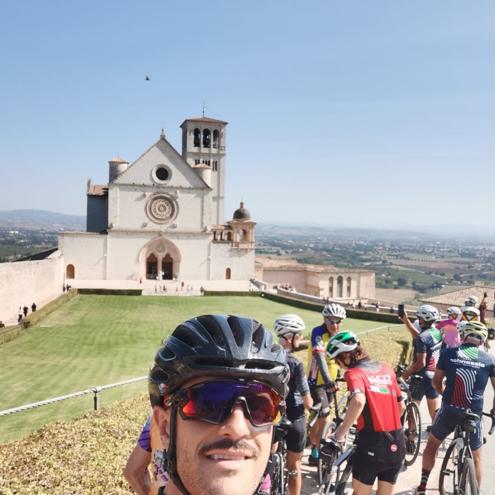 A holiday near Assisi: activities galore Group of cyclists in front of Basilica of San Francesco in Assisi under clear sky