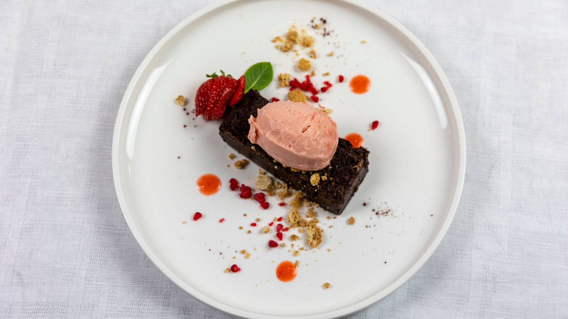 Umbrien: Unterkunft mit Restaurant Dessert mit Schokoladenkuchen, Erdbeereis und Erdbeeren mit Krümeln dekoriert