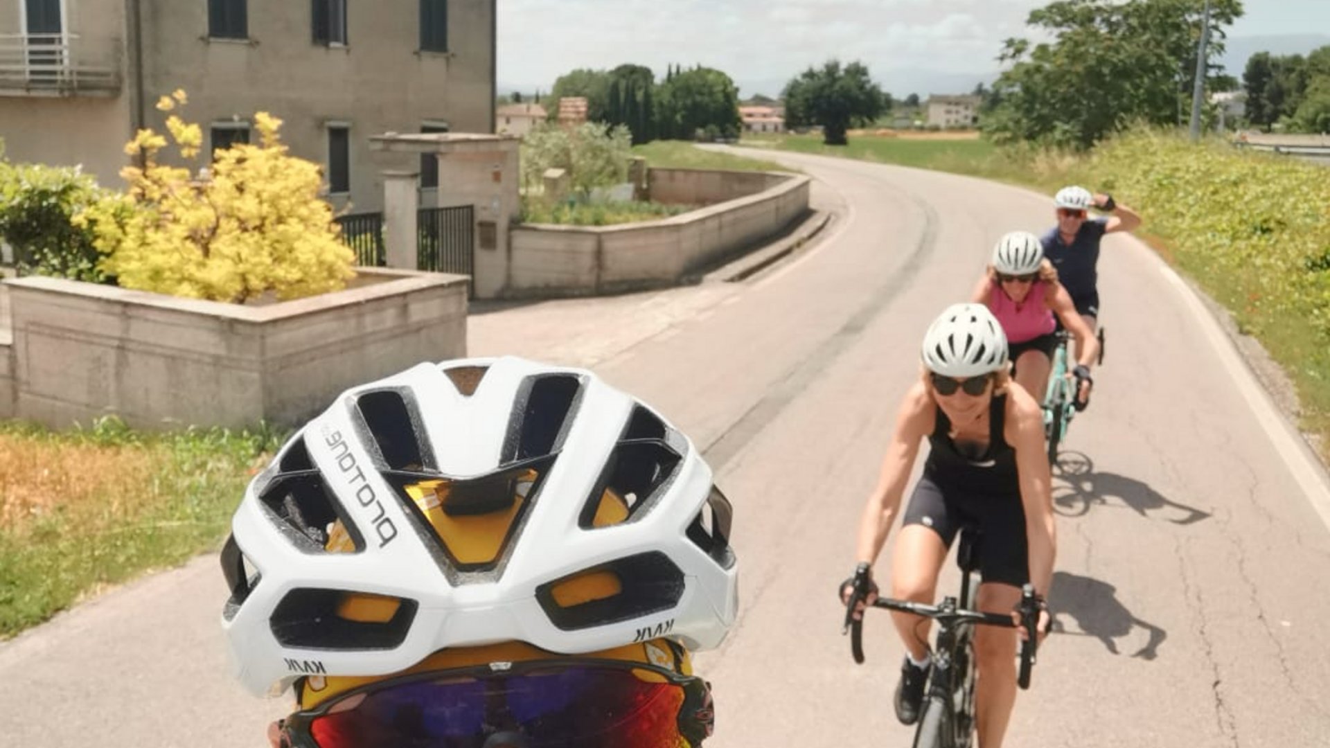 A holiday near Assisi: activities galore Group of cyclists in sportswear riding on a sunny road