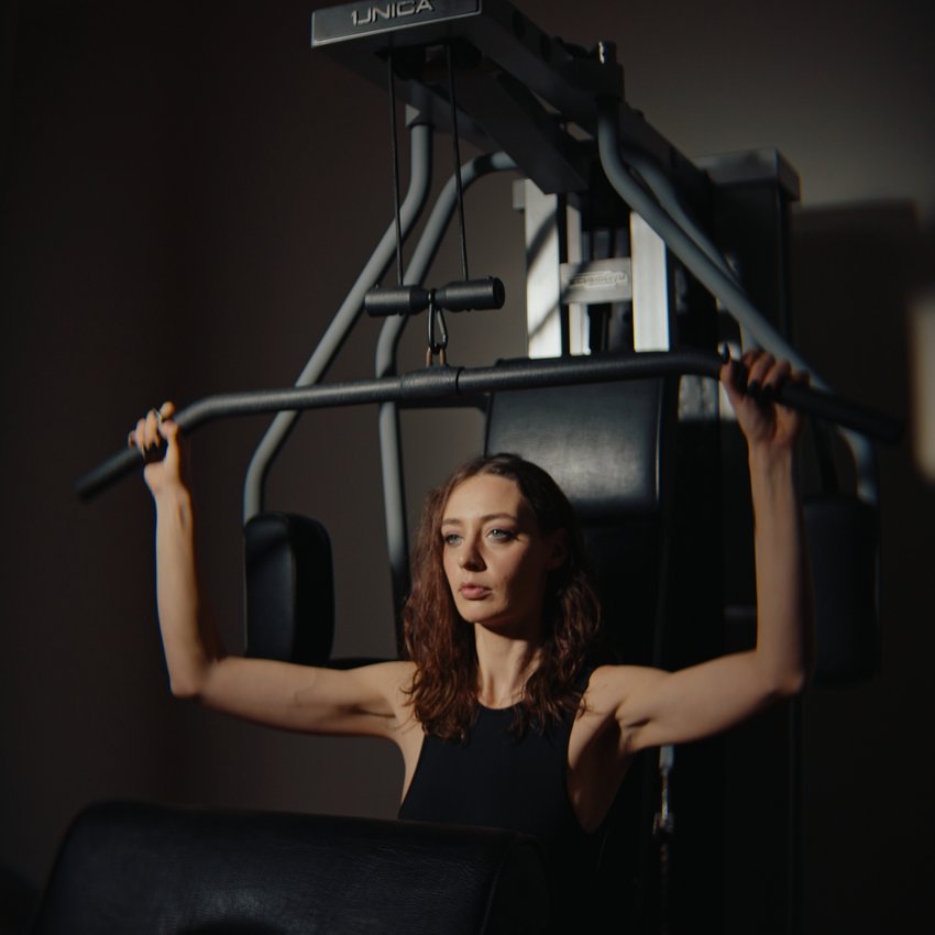 Un hotel con spa per famiglie e area fitness Donna che si allena con macchina per trazioni in palestra