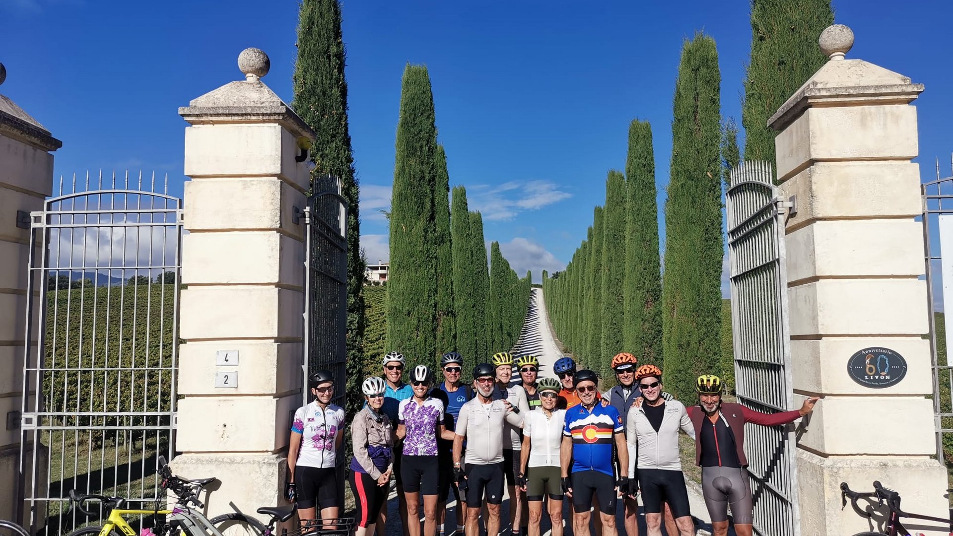 A holiday near Assisi: activities galore Group of cyclists in sportswear standing in front of a gate with tall trees