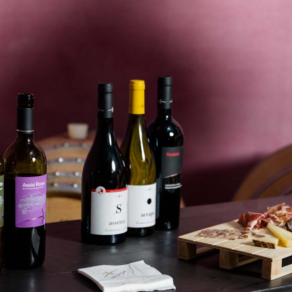 A hotel for families in Umbria with that little extra Set of wine bottles and wooden board with cold cuts and cheese on table