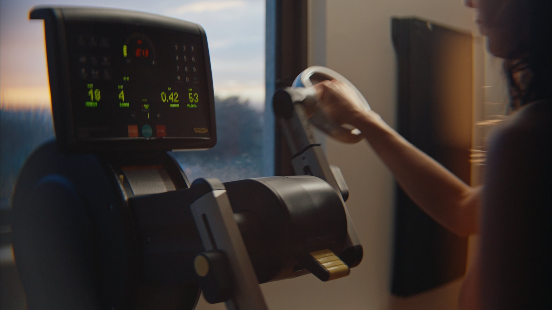 Un hotel con spa per famiglie e area fitness Donna che usa una macchina per esercizi con display digitale vicino a una finestra