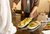Weekend romantico in Umbria, il cuore verde d’Italia Persona versa olio d'oliva su fette di pane tostato con insalata su piatti bianchi