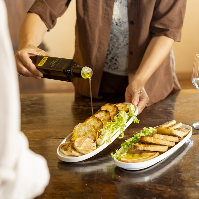 SPA in gravidanza Persona versa olio d'oliva su fette di pane tostato con insalata su piatti bianchi