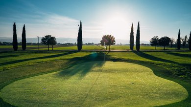 A holiday near Assisi: activities galore Golf course at sunset with trees and low sun on the horizon