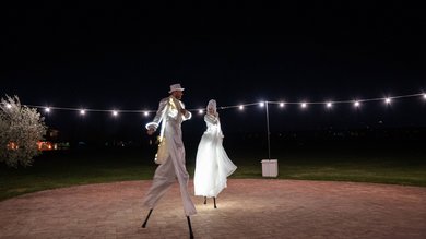 Perugia ha un Centro Meeting e Congressi d'eccezione: ai piedi di Assisi in Umbria Due artisti su trampoli con costumi bianchi illuminati di notte all'aperto