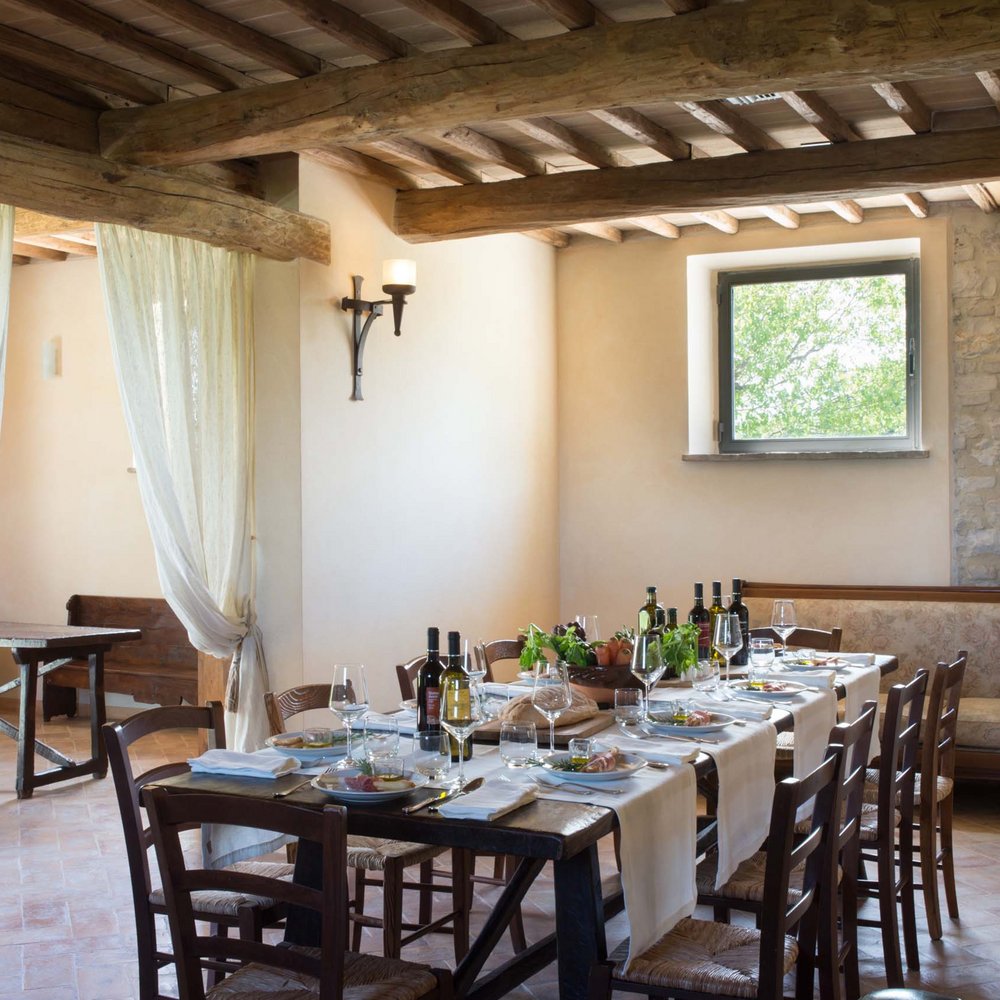 Ferienhaus in Umbrien mit Pool: in unserem Resort Rustikal gedeckter Tisch in rustikalem Raum mit Holzbalken und Sichtsteinwand