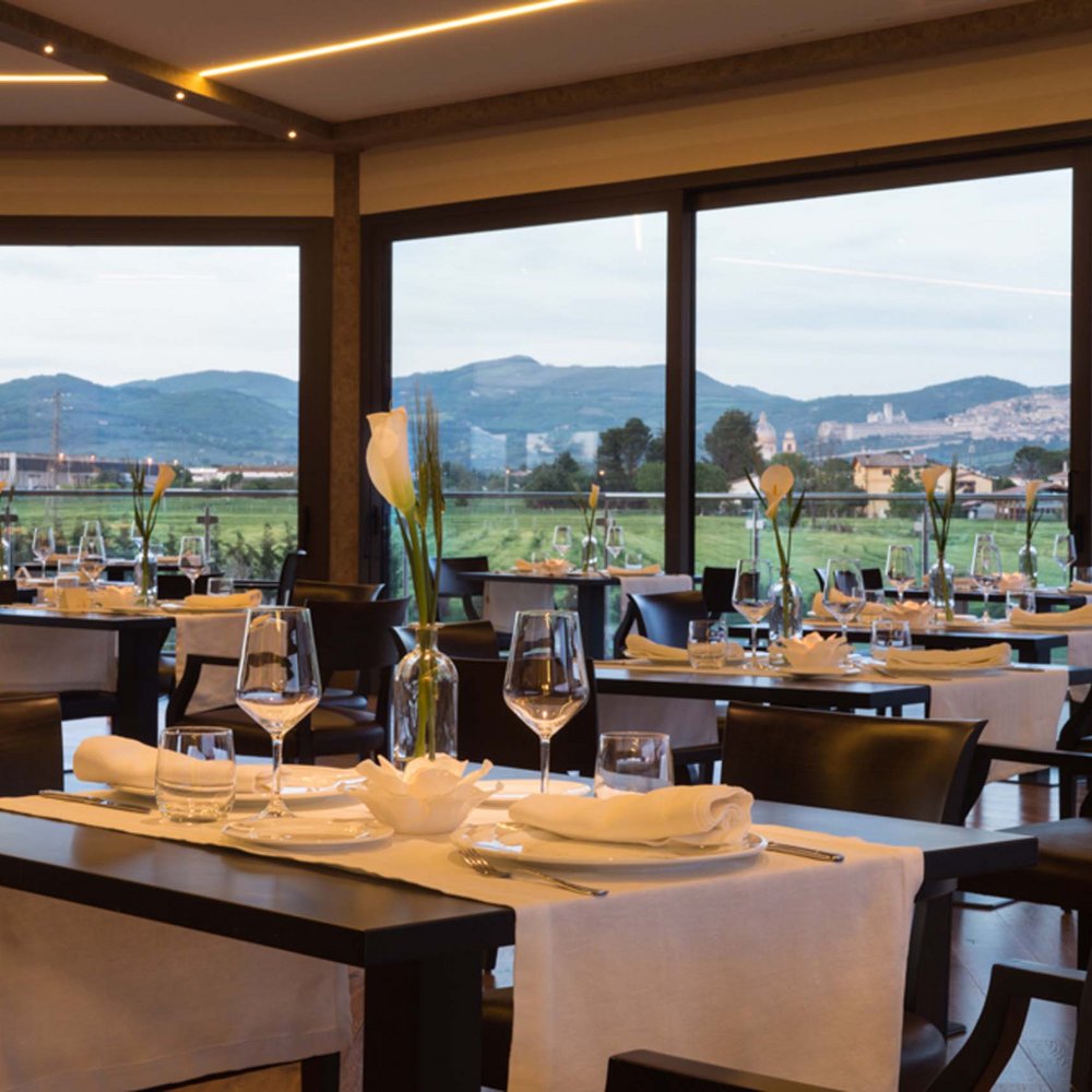 Umbrien: Unterkunft mit Restaurant Elegantes Restaurant mit gedeckten Tischen und Blick auf Hügel