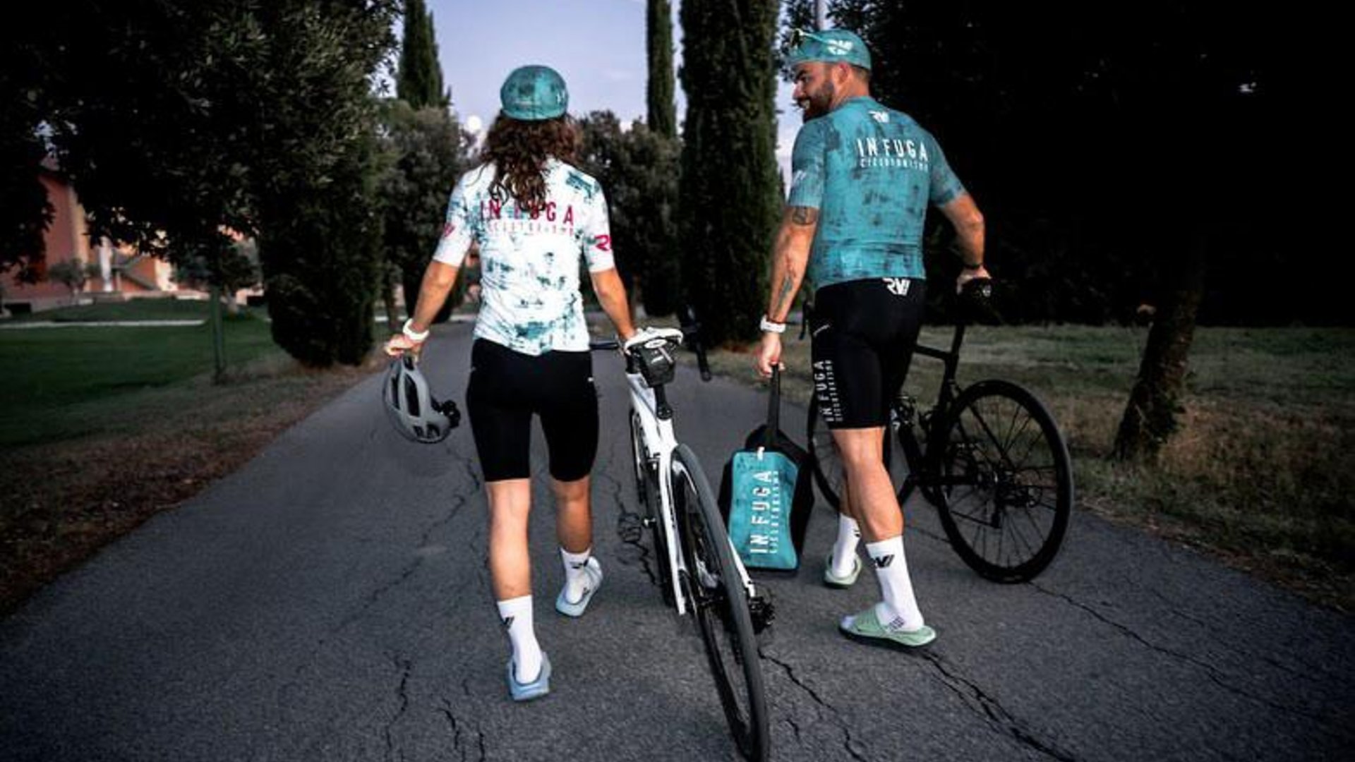 A holiday near Assisi: activities galore Two cyclists walking with their bikes on a tree-lined road
